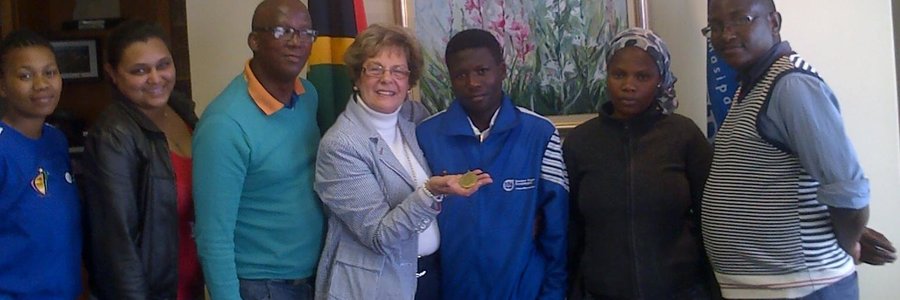 Grade 8 Overstrand learner, Thabile Gquira (pictured centre) proudly shows off the gold medal he won at the recent National Indigenous games.  Thabile is flanked by Executive Mayor Nicolette Botha-Guthrie to his left and his guardian and sister, Ncediswa Gqira to his right.  Also in attendance were officials from the Western Cape Department of Cultural Affairs and Sport (DECAS).
